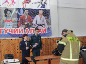 Людмила Кулаева  главный судья на олимпиаде школьников по ОБЗР при выполнении задания № 5 «Надевание боевой одежды пожарного».